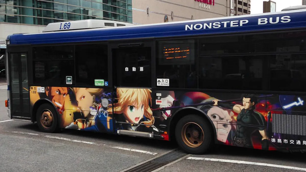 city bus wrapped in prequel anime art at Tokushima Station during a local promotion