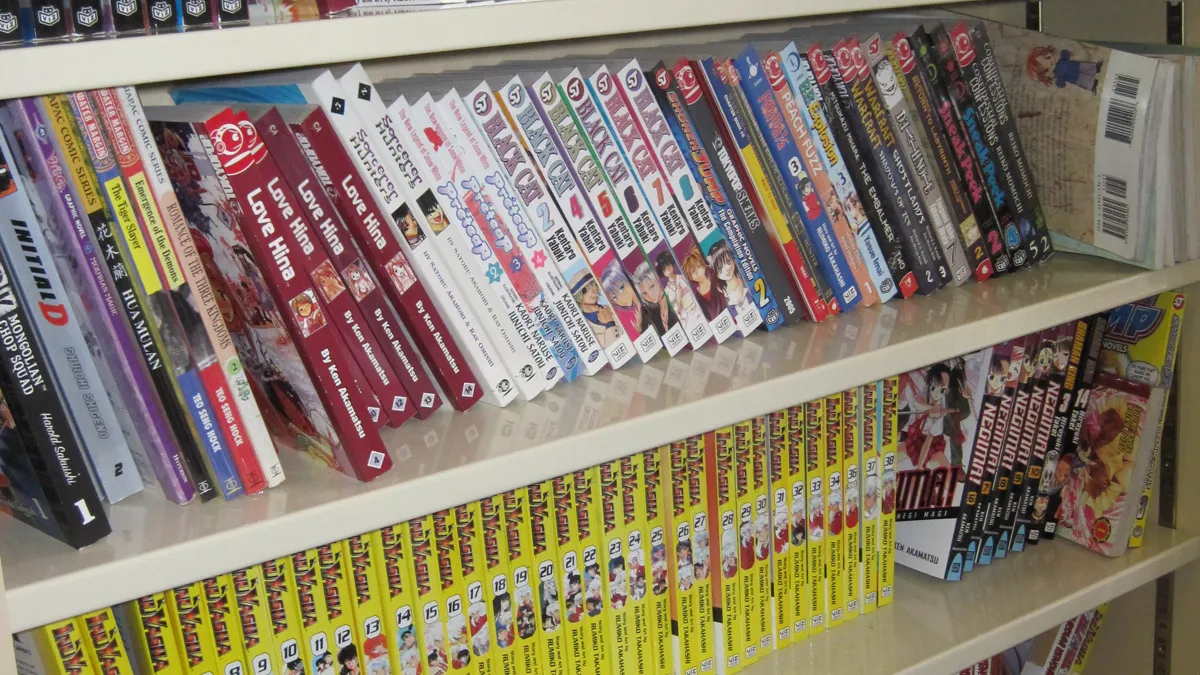 English Manga Volumes on a Bookstore Shelf Shelf of English translated manga volumes, where publishers choose to keep or drop name suffixes