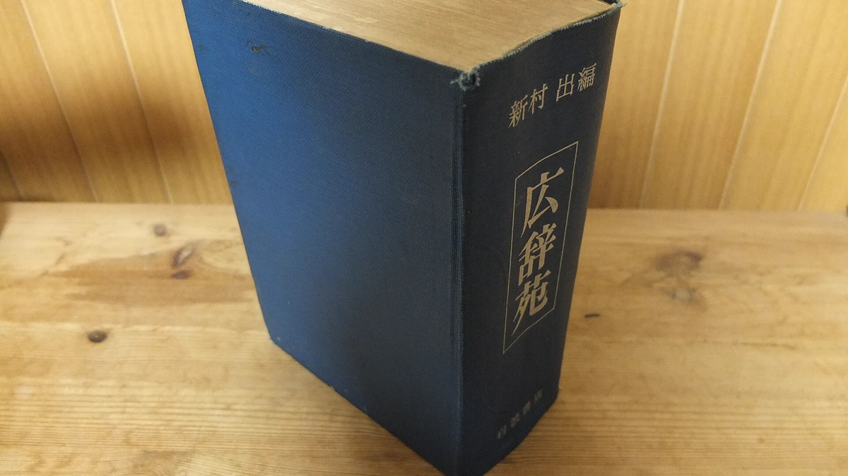 Second Edition Kojien Japanese Dictionary kuudere meaning looked up in a Kojien Japanese dictionary, a worn second edition on a wooden table