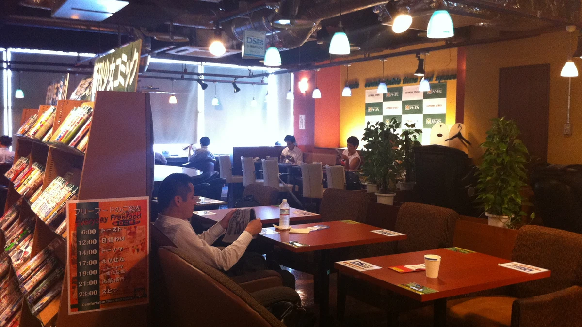 manga kissa cafe library shelves stocked with categorized comic book tankobon volumes