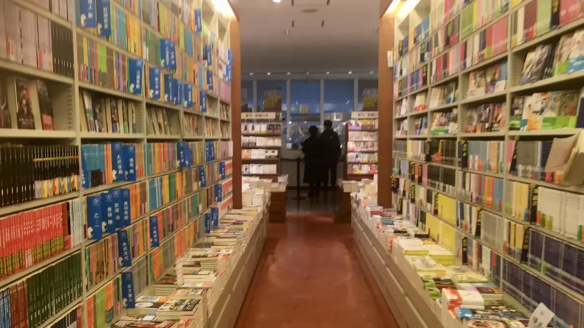what is shonen manga guide showing serialized volume shelves in a tokyo bookstore